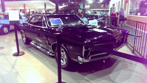2000 Mercury Grand Marquis - A classic black Pontiac GTO is displayed indoors, with a blue sign on its dashboard.