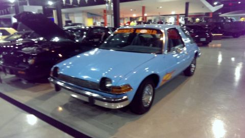 2000 Mercury Grand Marquis - A light blue AMC Pacer with flame decals is parked indoors, with other vehicles visible in the background.