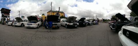 2000 Mercury Grand Marquis - Several sedans, including a white 2000 Mercury Grand Marquis, are parked with their hoods open at an outdoor event.