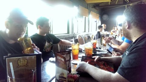2000 Mercury Grand Marquis - A group of people are gathered around tables in a restaurant, enjoying drinks and looking at menus.