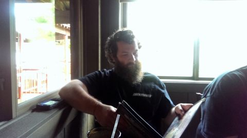2000 Mercury Grand Marquis - A man with a large beard sits indoors, with a phone visible on the windowsill next to him.
