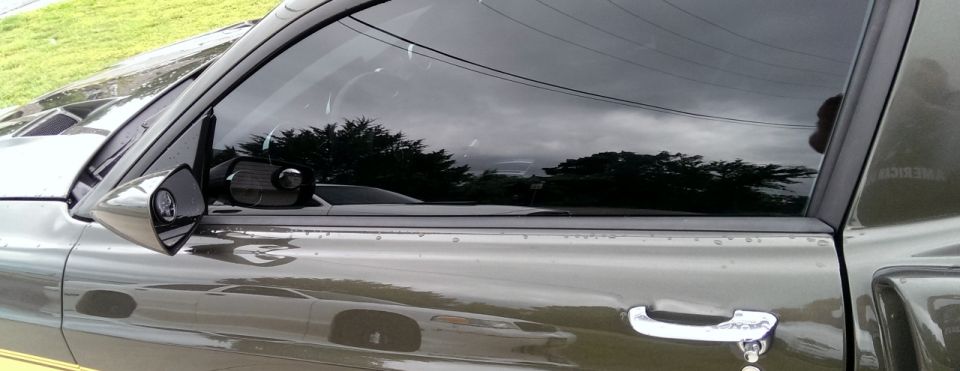 Side view mirror and door handle on a dark-colored vehicle. "SUPERMOTORS" text visible