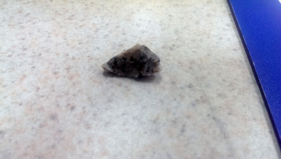 Rock on speckled countertop next to blue binder