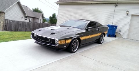 2000 Mercury Grand Marquis - A classic 1969 Ford Mustang Shelby GT500 is seen in a driveway next to a garage.