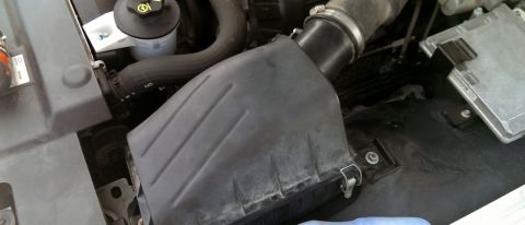2000 Mercury Grand Marquis - Close-up view of the engine bay, focusing on the air intake housing and electronic control unit.