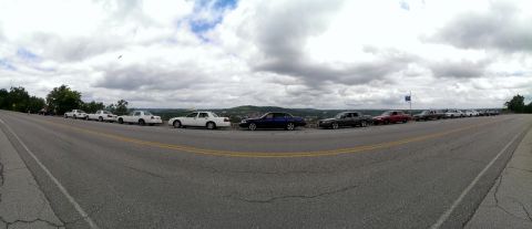 2000 Mercury Grand Marquis - Multiple Mercury Grand Marquis sedans are parked in a line along a road with a scenic view.