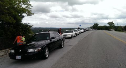 2000 Mercury Grand Marquis - A group of Mercury Grand Marquis sedans are parked in a line on a scenic overlook.