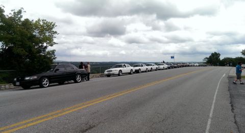 2000 Mercury Grand Marquis - A gathering of Mercury Grand Marquis sedans are parked along a scenic overlook on a cloudy day.
