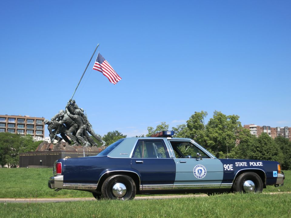 Rear-three-quarter view of Massachusetts State Police Ford sedan near Iwo Jima Memorial