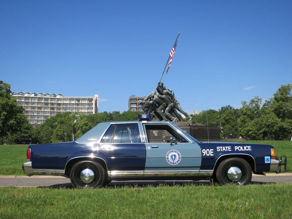 Massachusetts State Police Ford sedan parked on grass before the Iwo Jima Memorial