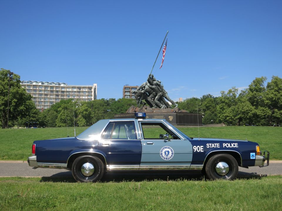 Rear-quarter view of two-tone blue Massachusetts State Police 90E cruiser by Iwo Jima Memorial