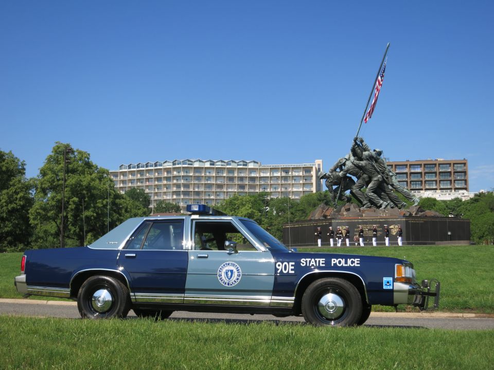 Side profile of two-tone blue Massachusetts State Police 90E cruiser near Iwo Jima Memorial