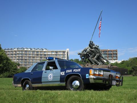 1991 Ford LTD Crown Victoria - two-tone blue State Police cruiser with brush guard parked on a lawn in front of the Marine Corps War Memorial.