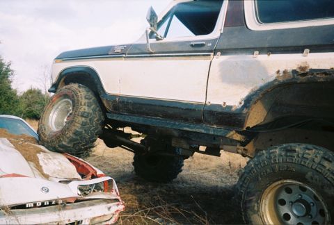 1978 Ford Bronco - Ford Bronco crushing a car, showing its off-road capabilities.