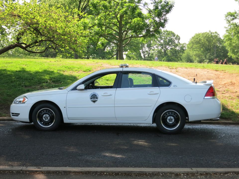 White Chevrolet Impala police car in profile with light bar and door shield