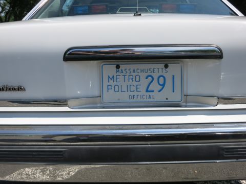 1991 Ford LTD Crown Victoria - Close-up of the rear of a white Ford Crown Victoria showing a Massachusetts 'Metro Police Official 291' license plate.