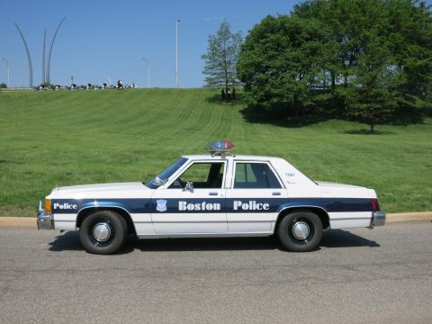 1991 Ford LTD Crown Victoria - white and blue 'Boston Police' Ford LTD sedan with roof lightbar parked on a road beneath the Air Force Memorial spires.