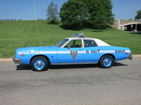 1991 Ford LTD Crown Victoria - Profile of a light blue and white 'Police 5 PCT 2655' sedan with shield door emblem and roof lights parked on a road.