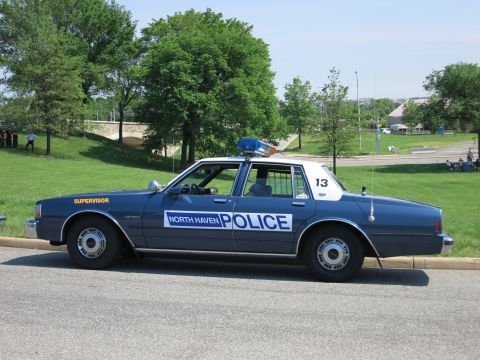 1991 Ford LTD Crown Victoria - dark blue sedan lettered NORTH HAVEN POLICE and Supervisor, numbered 13, is parked roadside beside a grassy slope.
