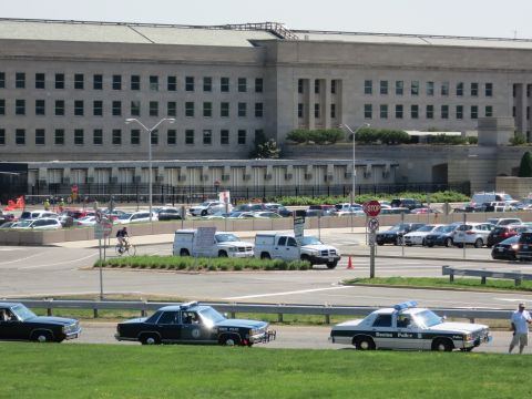 1991 Ford LTD Crown Victoria - Black-and-white police cruisers, one marked Boston Police, sit on grass before a large stone government building and parking lot.