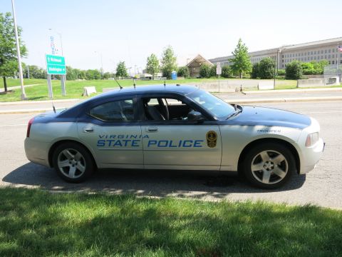 1991 Ford LTD Crown Victoria - silver 'Virginia State Police' Dodge Charger shown in full profile parked along a road, with the Pentagon behind it.