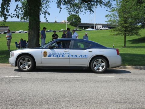 1991 Ford LTD Crown Victoria - silver 'Virginia State Police' Dodge Charger parked along a road with a group of spectators on the grass behind it.