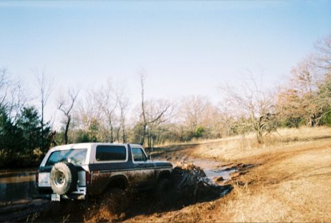 1978 Ford Bronco - This 1978 Ford Bronco navigates a muddy off-road trail with a spare tire mounted on the rear.