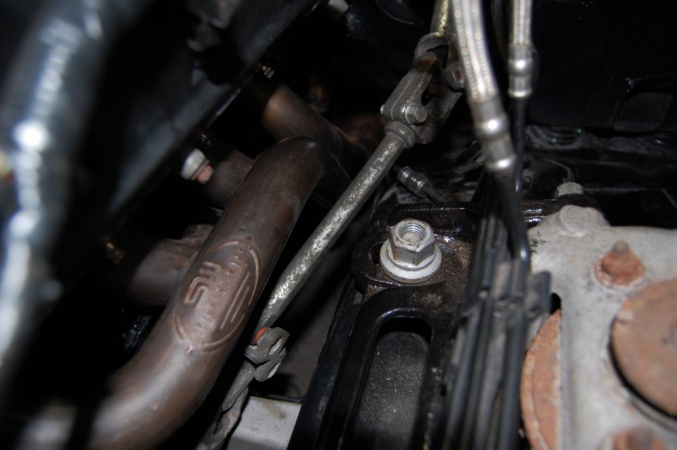 Engine bay detail showing a bolt, bracket and exhaust manifold