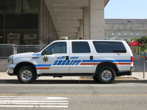 1991 Ford LTD Crown Victoria - white Ford Excursion SUV marked Nassau County Sheriff, unit 2710, parked curbside on a city street.