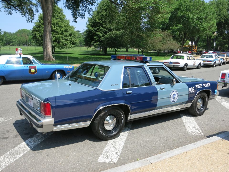 Two-tone blue Ford State Police sedan 90E rear quarter view in lot
