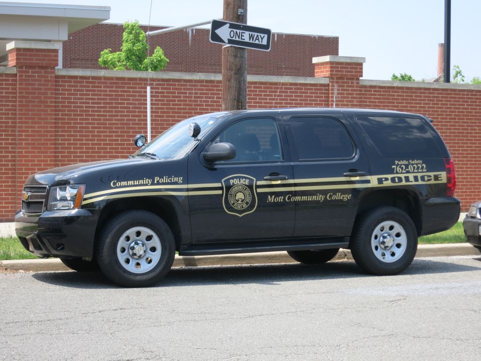 Black Chevrolet Mott Community College Police SUV by brick wall