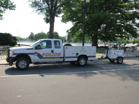 1991 Ford LTD Crown Victoria - white Ford Super Duty utility pickup marked United States Capitol Police towing a small white trailer near a reflecting pool.