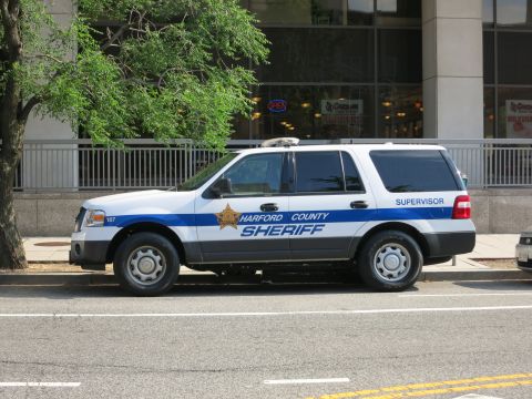 1991 Ford LTD Crown Victoria - white-and-blue Ford Expedition marked Harford County Sheriff Supervisor with a gold star parked along a street.