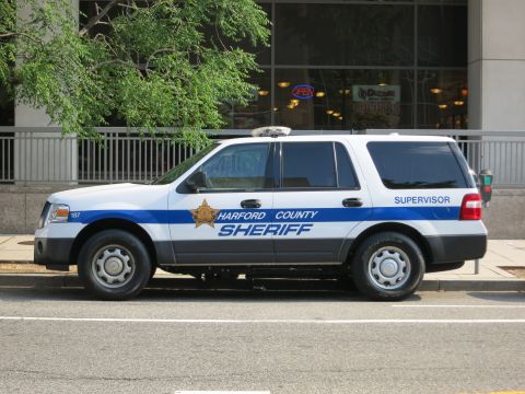 1991 Ford LTD Crown Victoria - Side view of a white-and-blue Ford Expedition lettered Harford County Sheriff Supervisor parked along a city street.