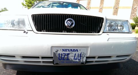 2000 Mercury Grand Marquis - Front view of a white 2000 Mercury Grand Marquis, its distinctive vertical grille and Nevada license plate.