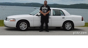 2000 Mercury Grand Marquis - Man poses with a white sedan, likely a Ford Crown Victoria or Mercury Grand Marquis, near a lake.