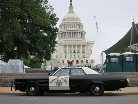 1991 Ford LTD Crown Victoria - Side profile of a black and white Highway Patrol sedan parked at a curb with the U.S. Capitol dome in the background.