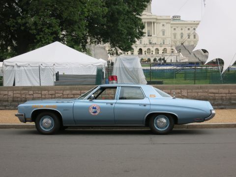 1991 Ford LTD Crown Victoria - Side profile of a light blue police sedan numbered 5 parked at a curb in front of white tents and the U.S. Capitol.