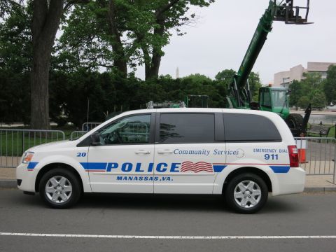 1991 Ford LTD Crown Victoria - white police minivan lettered POLICE Manassas VA Community Services parked near the Washington Monument and a green crane.