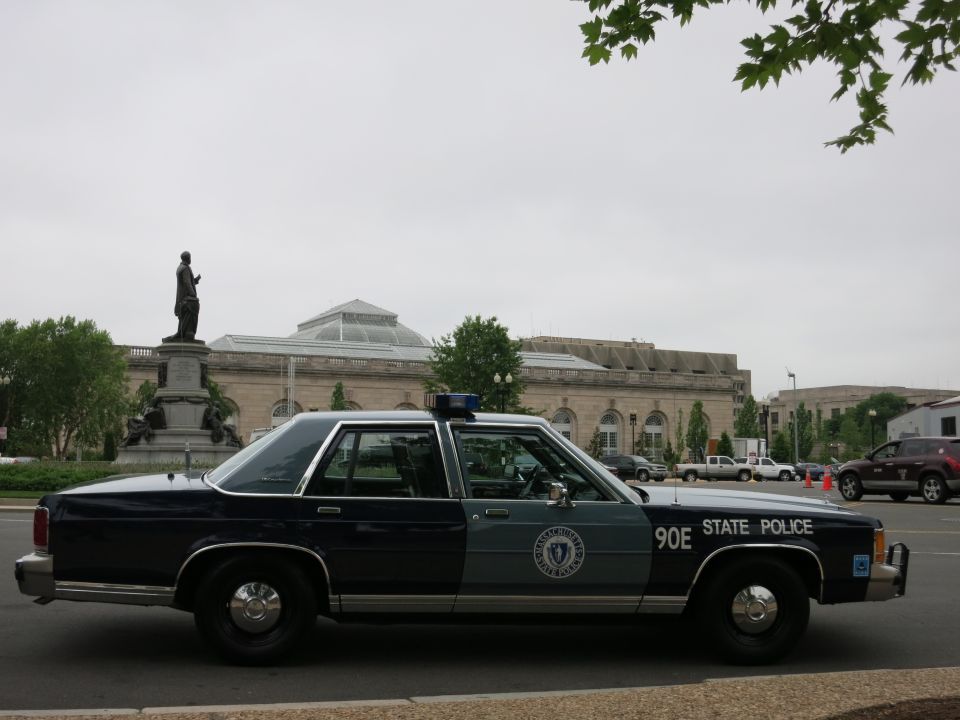 Dark blue Ford State Police sedan, number 90E, side view