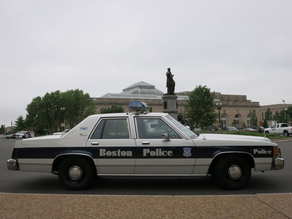 White and blue Boston Police Ford sedan parked near stone hall