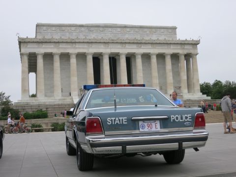 1991 Ford LTD Crown Victoria - Rear three-quarter view of a blue Ford STATE POLICE sedan marked 90 E parked in front of the Lincoln Memorial.