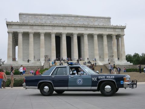 1991 Ford LTD Crown Victoria - Side view of a blue STATE POLICE sedan numbered 90E parked on the plaza before the columned Lincoln Memorial.