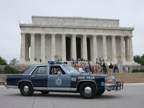 1991 Ford LTD Crown Victoria - blue Ford STATE POLICE sedan marked 90E parked on the plaza in front of the Lincoln Memorial as visitors gather.