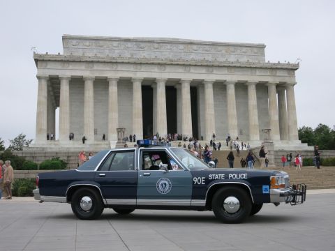 1991 Ford LTD Crown Victoria - blue STATE POLICE sedan numbered 90E with a circular door emblem parked before the columned Lincoln Memorial.