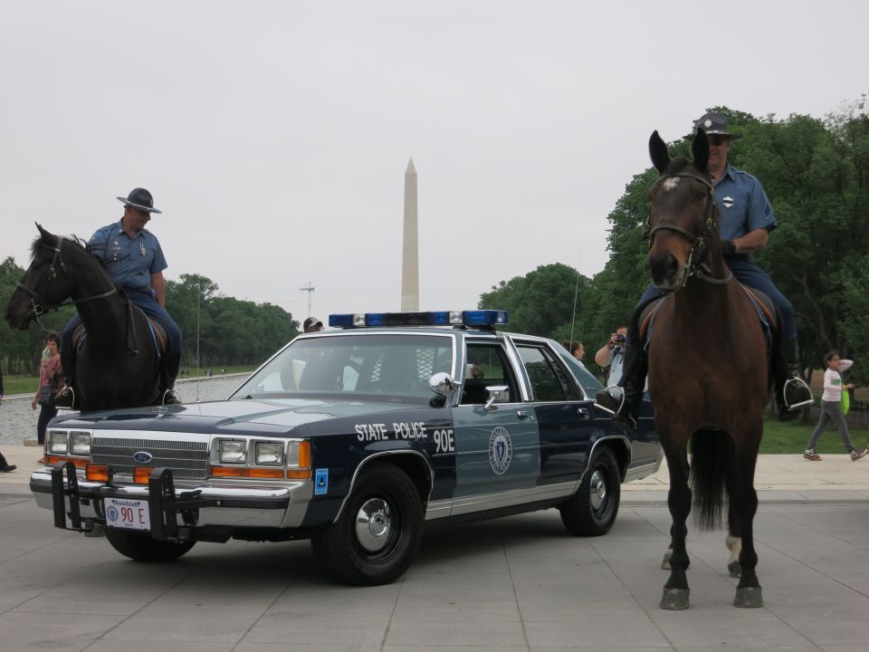 Two mounted officers beside a State Police cruiser near the Reflecting Pool