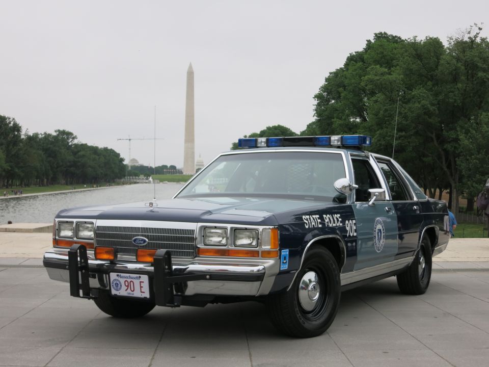Front three-quarter view of a State Police Ford cruiser, Washington Monument behind