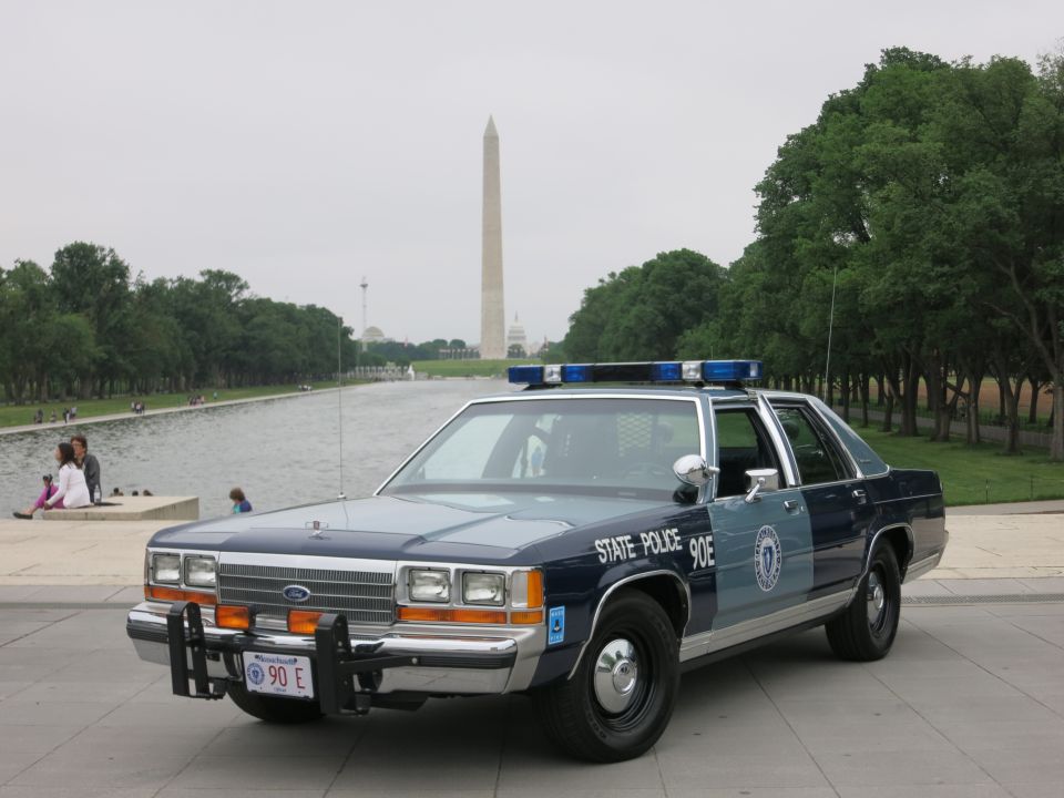 Blue and silver State Police Ford patrol sedan front view, Washington Monument