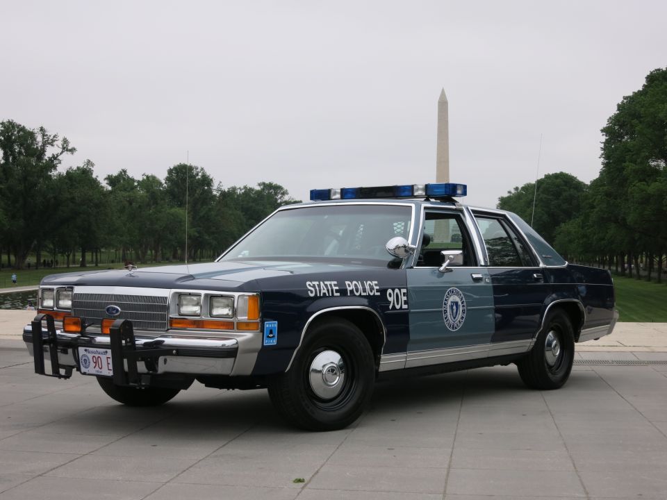 Blue and silver State Police Ford patrol sedan, Washington Monument behind