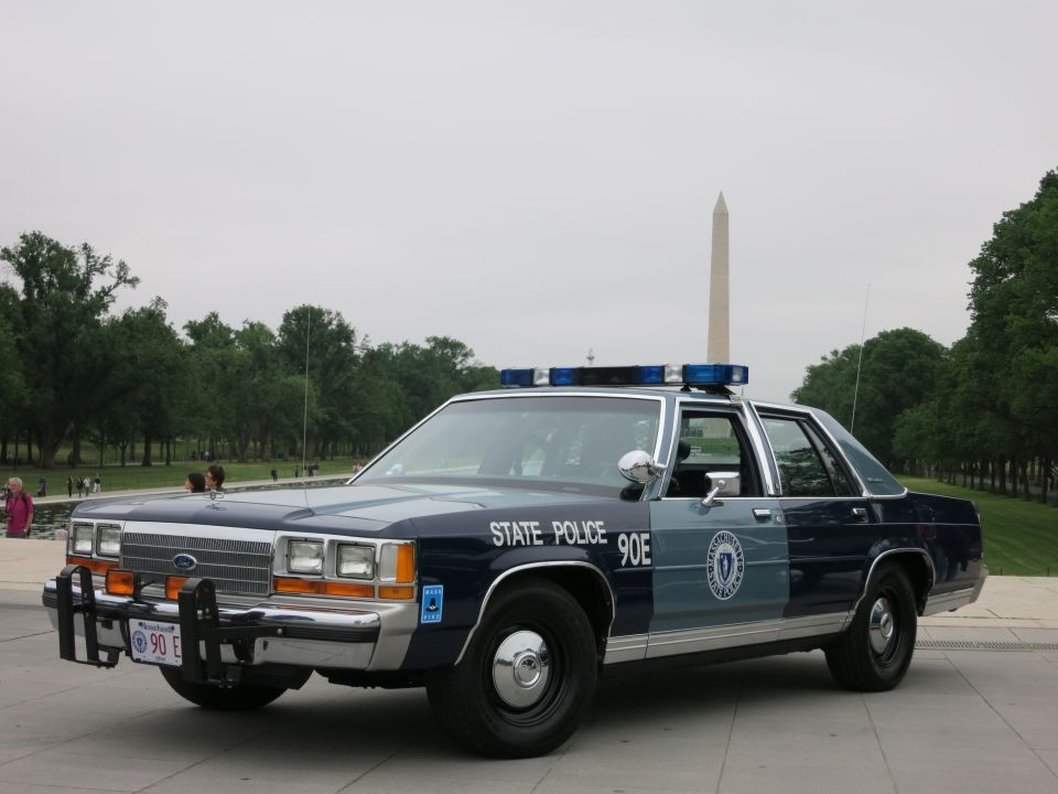 Blue and silver State Police Ford patrol sedan, Washington Monument behind